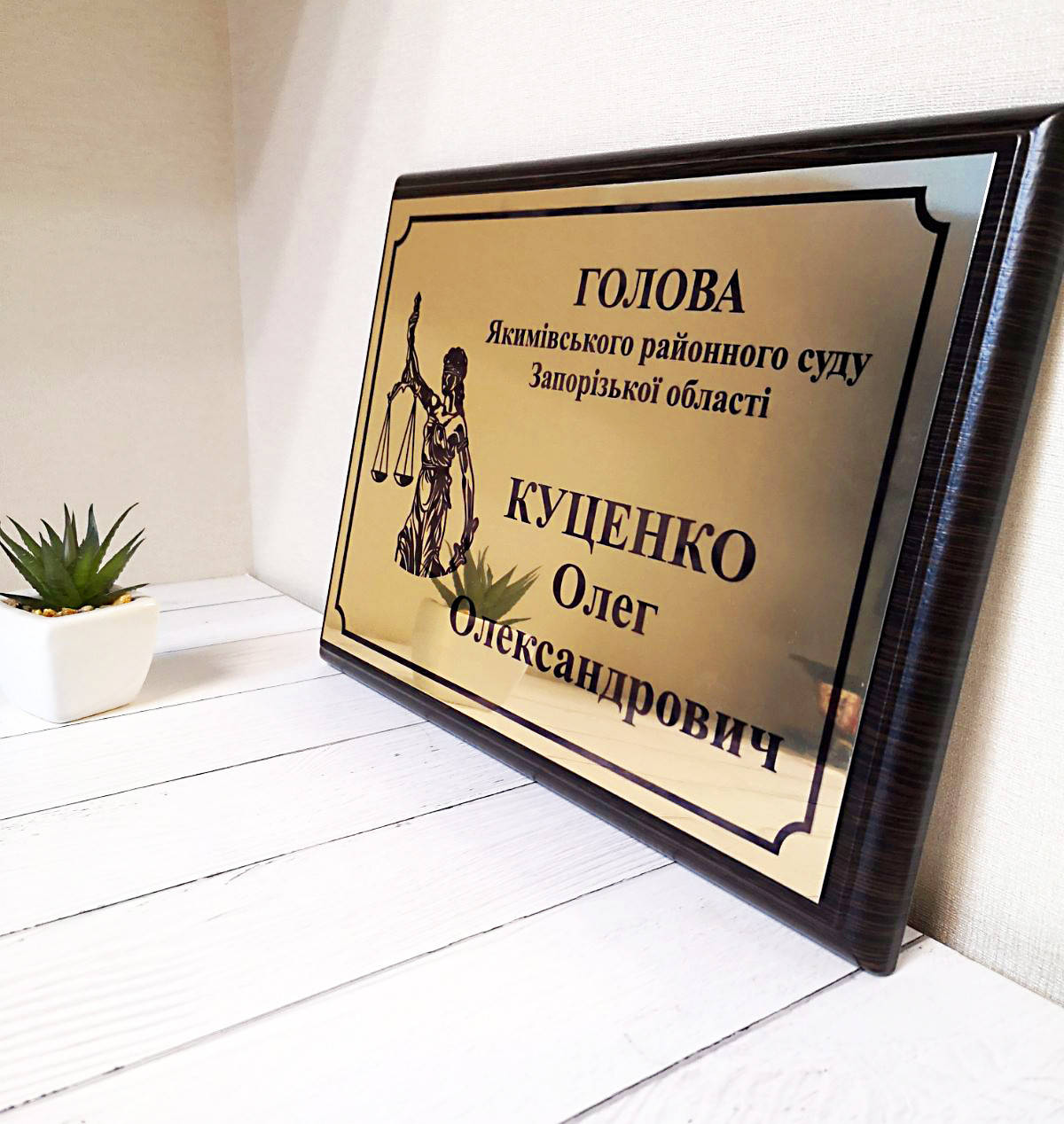 

Металлическая табличка на деревянной основе с фемидой
