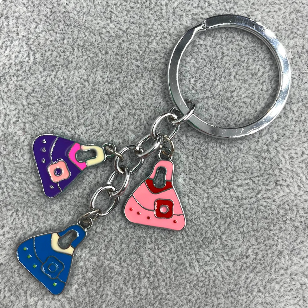 Брелок металевий сріблястого кольору різнобарвні сумочки покритий кольоровою емаллю довжина 8,5 см - фото 1 - id-p1697830461
