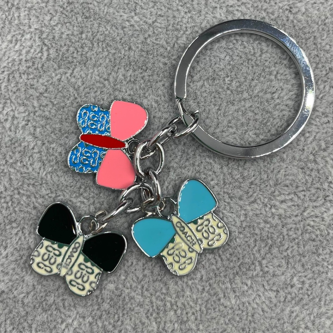 Брелок металевого сріблястого кольору різнобарвні метелики з візерунками покритий кольоровою емаллю довжина 8,5 см - фото 1 - id-p1699146429