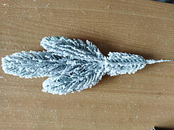 Соснова гілка блакитна трійка в снігу