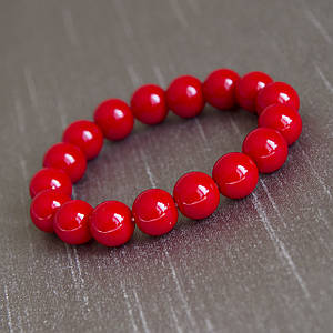 Браслет жіночий із круглих намистин червоного кольору корал на гумці 17 намистин діаметр намистин 12 мм