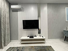 Декоративні стінові панелі в білому кольорі decorpaneli у вітальні біля телевізора