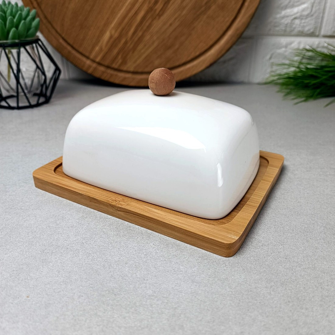 Біла порцелянова маслянка на бамбуковій підставці закруглені краї