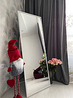 Підлогове дзеркало в тонкій білій рамі на ніжці