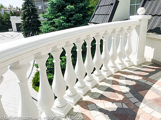 Белая балюстрада с квадратными тумбами ограждает террасу над входной группой