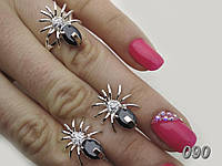 Комплект женских украшений - кольцо и серьги в виде паучков из серебра с фианитами и золотыми пластинами.