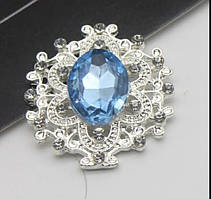Камінь в сріблястій ажурній оправі 24*26 мм світло-синій