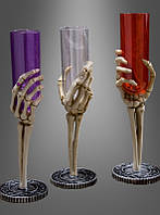 Красный бокал для шампанского с рукой скелета