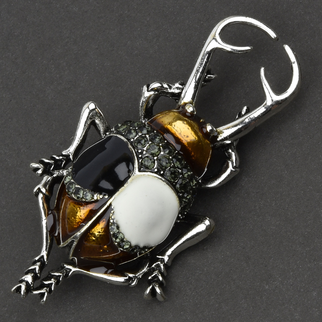 Брошка металева на сріблястій основі жук із сірими стразами покрита кольоровою емаллю розмір 60х30 мм