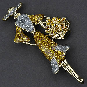 Брошка металева на золотистій основі дамочка в капелюсі з квітами покрита кольоровою емаллю розмір 75х40 мм