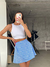 Жіночий літній костюм: білий топ і коротка блакитна спідниця