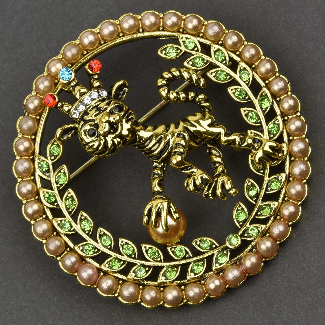 Брошка металева на золотистій основі тигр із короною із салатовими стразами та намистинами розмір 45х45 мм