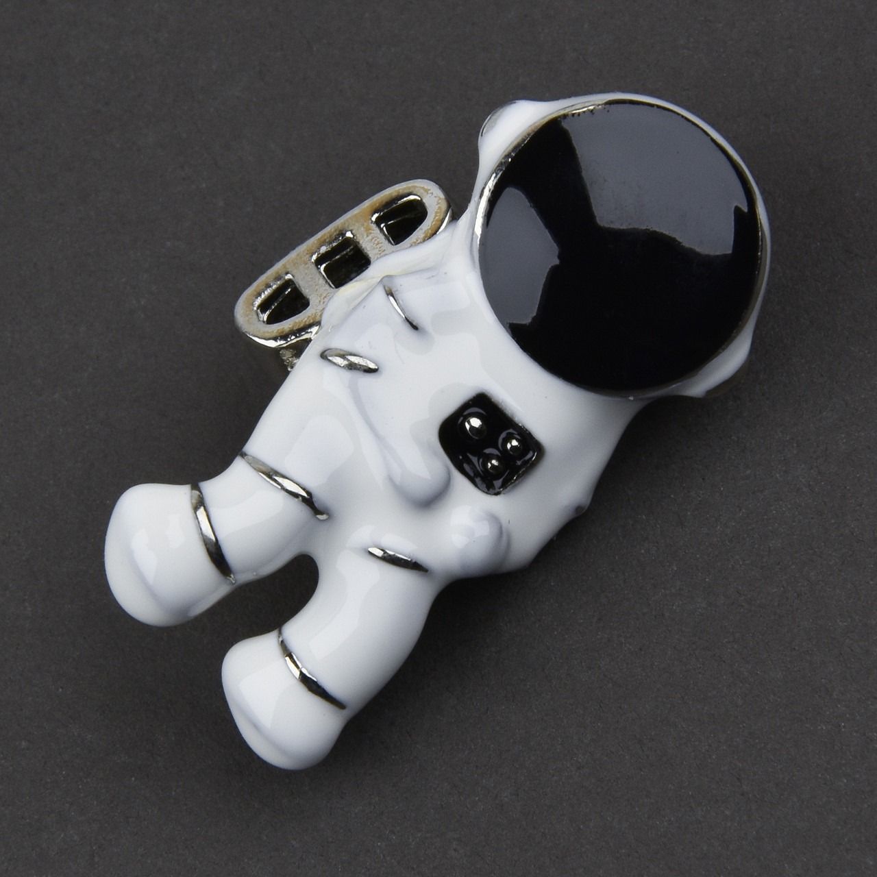 Брошка металева на сріблястій основі людина космонавт покритий чорною білою емаллю розмір 35х20 мм