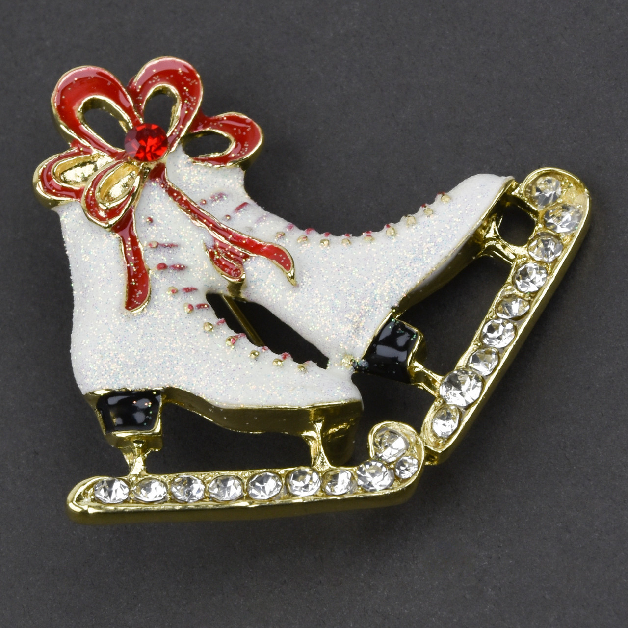 Брошка металева на золотистій основі ковзани з бантиком і стразами покрита кольоровою емаллю розмір 45Х50 мм