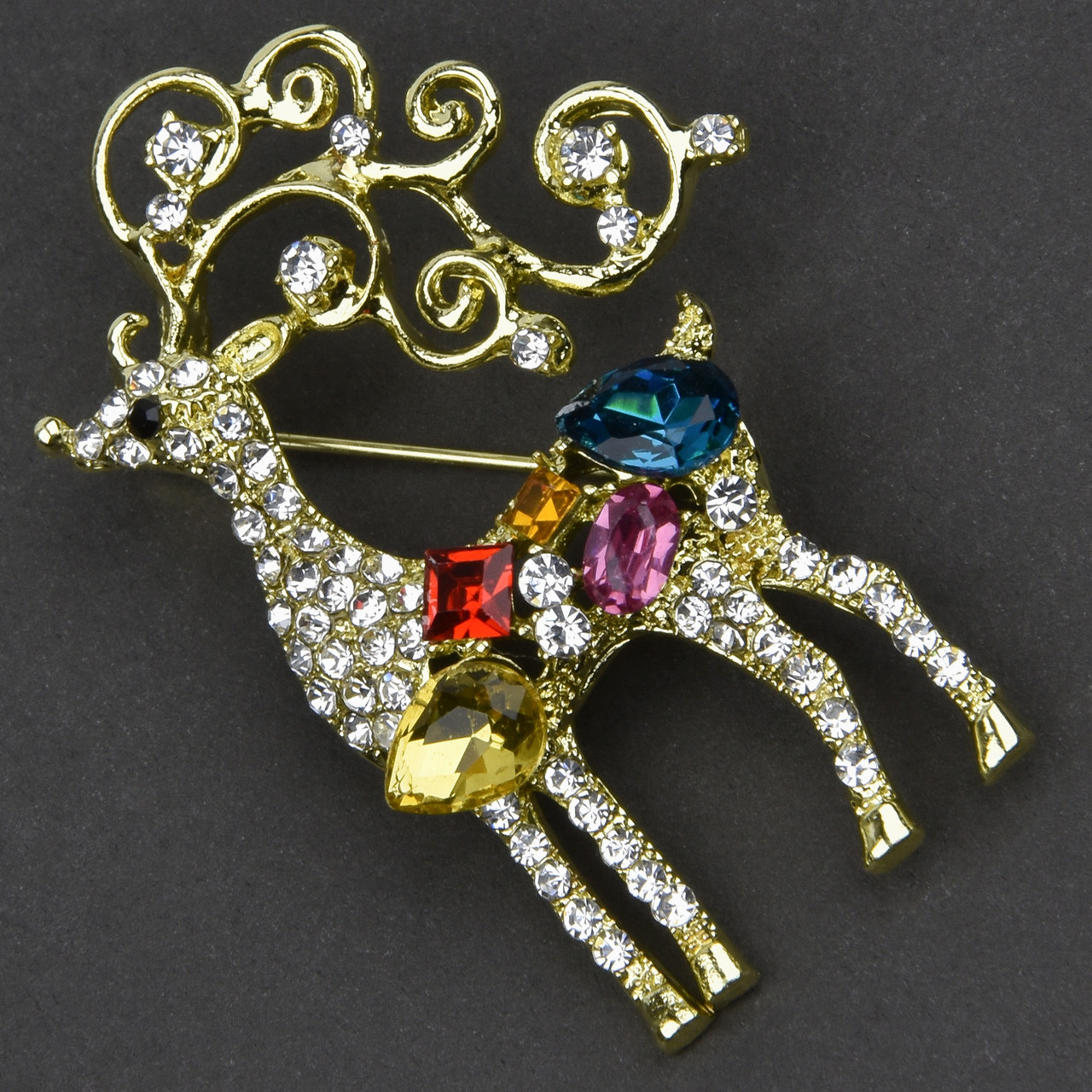 Брошка металева на золотистій основі олень із різнобарвними кристалами та білими стразами розмір 50х20 мм
