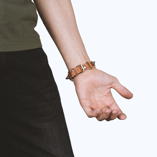 Фото браслет на руку шкіряний з металевими шипами коричневий