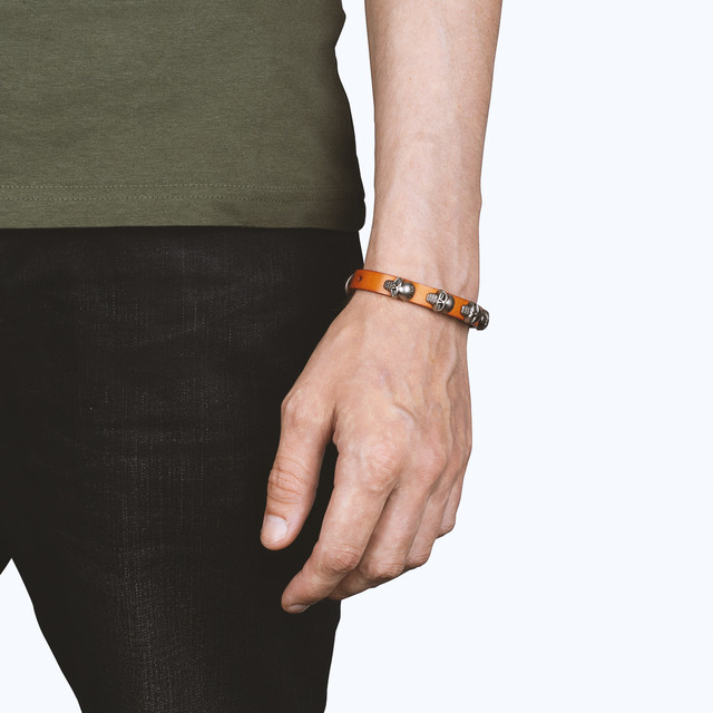 Фото браслет на руку шкіряний з черепами помаранчевий Фото браслет на руку шкіряний з черепами помаранчевий