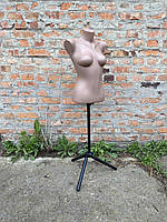 Манекен жіночий торс тілесного кольору на чорній ніжці.