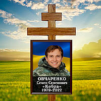 Табличка на надгробі для військового з фото та сприченим на тлі прапору України