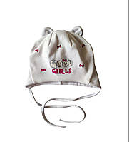 Біла трикотажна шапочка із зав'язками для дівчинки