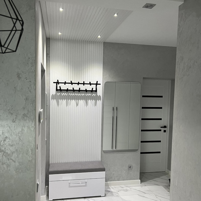 Стінові рейкові панелі білі у коридорі біля квадратного дзеркала