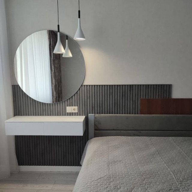 Мінімалізм. Стінові рейкові панелі коліт бетон темний, у спальні з круглим дзеркалом
