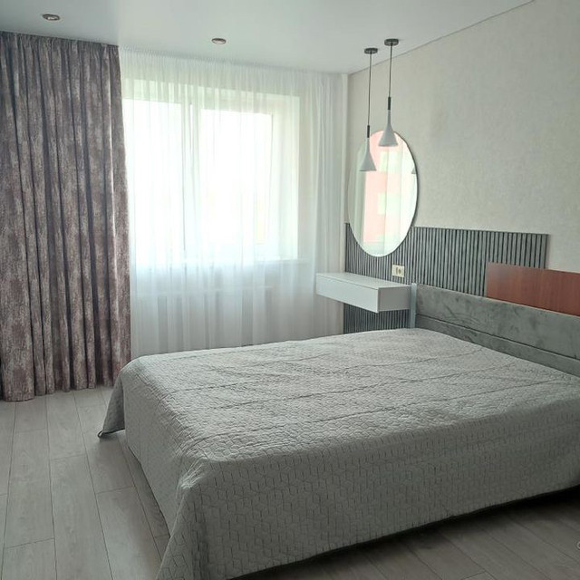 Стінові рейкові панелі колір бетон темний, у спальні біля ліжка та круглого дзеркала