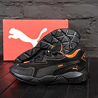 Чорні кросівки з помаранчевими вставками на текстильній підкладці.