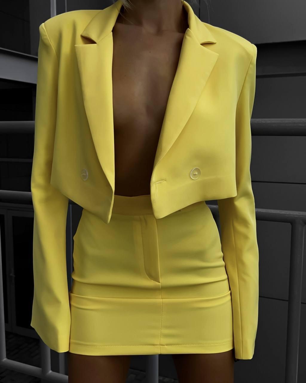 Яскравий жовтий стильний жіночий костюм з костюмки: Облягаюча міні-спідниця і вкорочений піджак з плічками