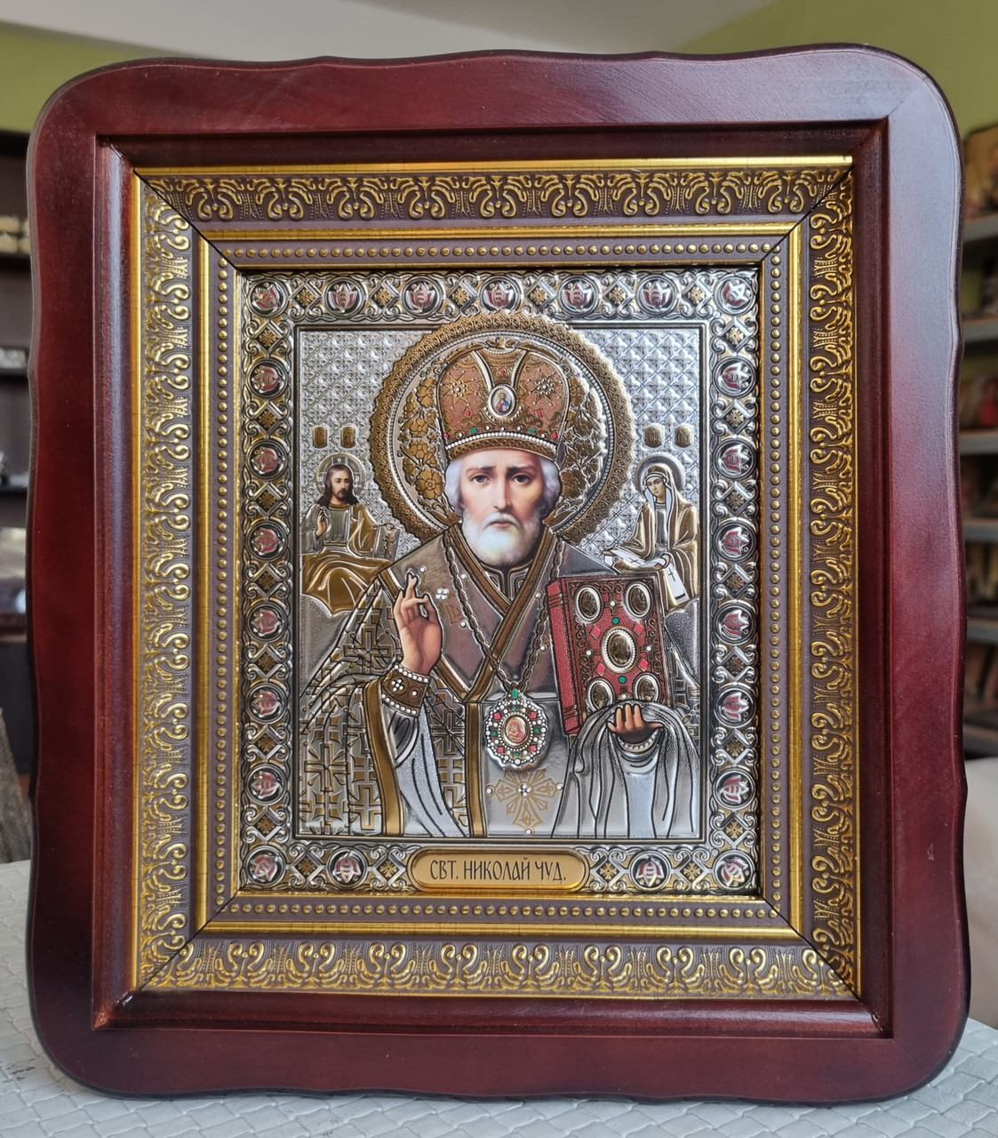 Ікона Святий Миколай Чудотворець під срібло у темному фігурному дерев'яному кіоті під склом, кіот 26*23, сюжет 15*18.