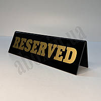 Табличка "RESERVED" на стіл з золотистими літерами