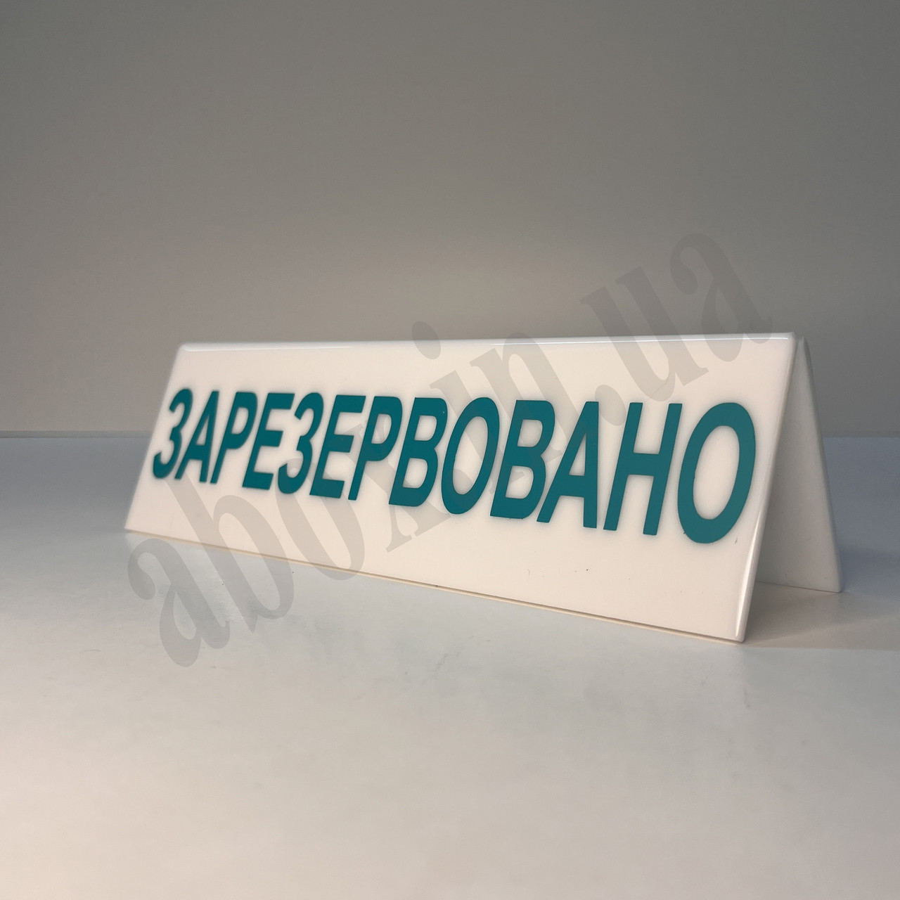 Біла настільна табличка "Зарезервовано" з бірюзовими літерами