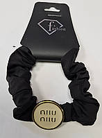 Шелковая черная резинка с брендовым украшением "Miu miu".