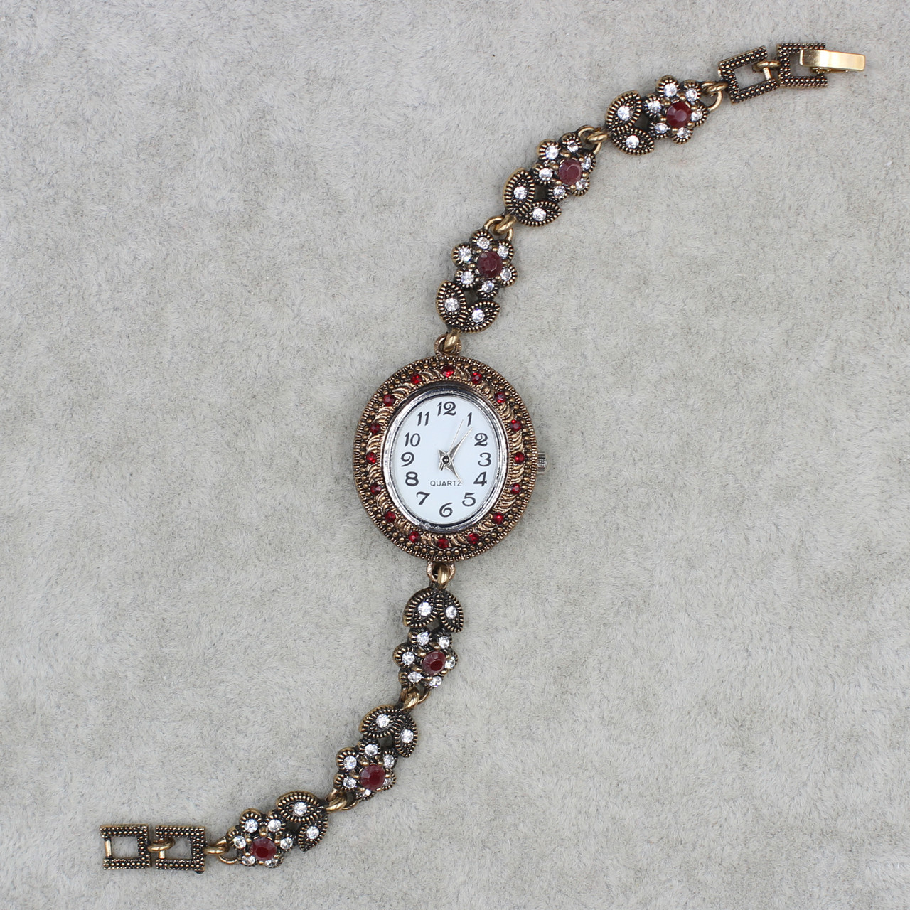 Женские часы наручные овальные кварцевые бижутерный сплав металл в золотистом цвете с рубиновыми камнями
