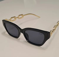 Солнцезащитные очки с темными стеклами в черной оправе и имитацией золотой цепочки из качественного пластика
