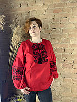 Женская вышиванка на красном домотканом полотне с черными нитями.