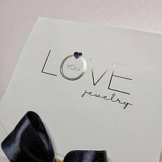 Шовкодрук + тиснення золотой фольгой на коробочках з білого крейдованого картону розміром 115*115*50 мм на стрічці.