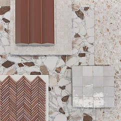 Некоторые терракотовые тона довольно яркие и сильные, часто рекомендуется сочетать их с более простыми формами, цветами и форматами. В данном случае мы рискнули и предложили напольную плитку тераццо с теми же оттенками.