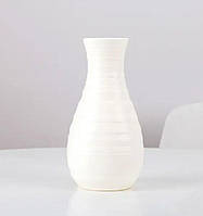 Ваза для квітів білого кольору.