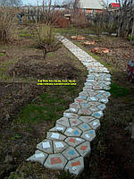 При создании садовой дорожки при помощи пластиковой формы для заливки дорожек можно добавить кусочки битой плитки. Внимание, такая дорожка будет скользкой.