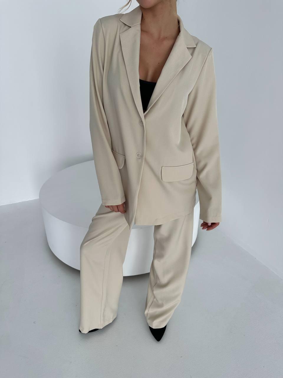 Бежевий жіночий стильний класичний костюм з костюмного тіару: подовжений піджак і широкі штани, фото 1