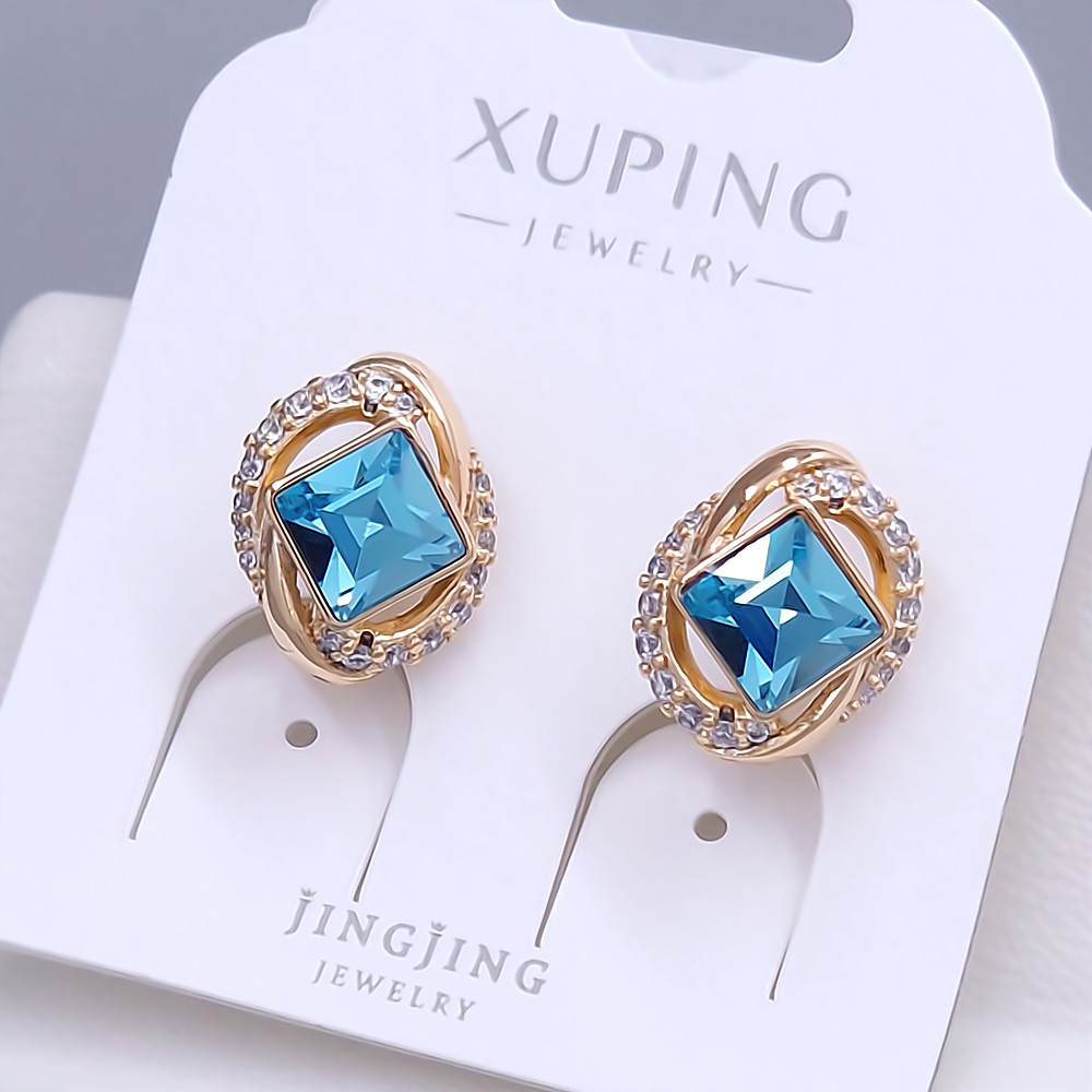 Сережки XР. Позолота 18К. Камені: Swarovski блакитного кольору та циркон. Довжина: 16 мм. Ширина: 11 мм.