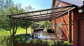 Веранда тнраса до будинку з прозорим дахом