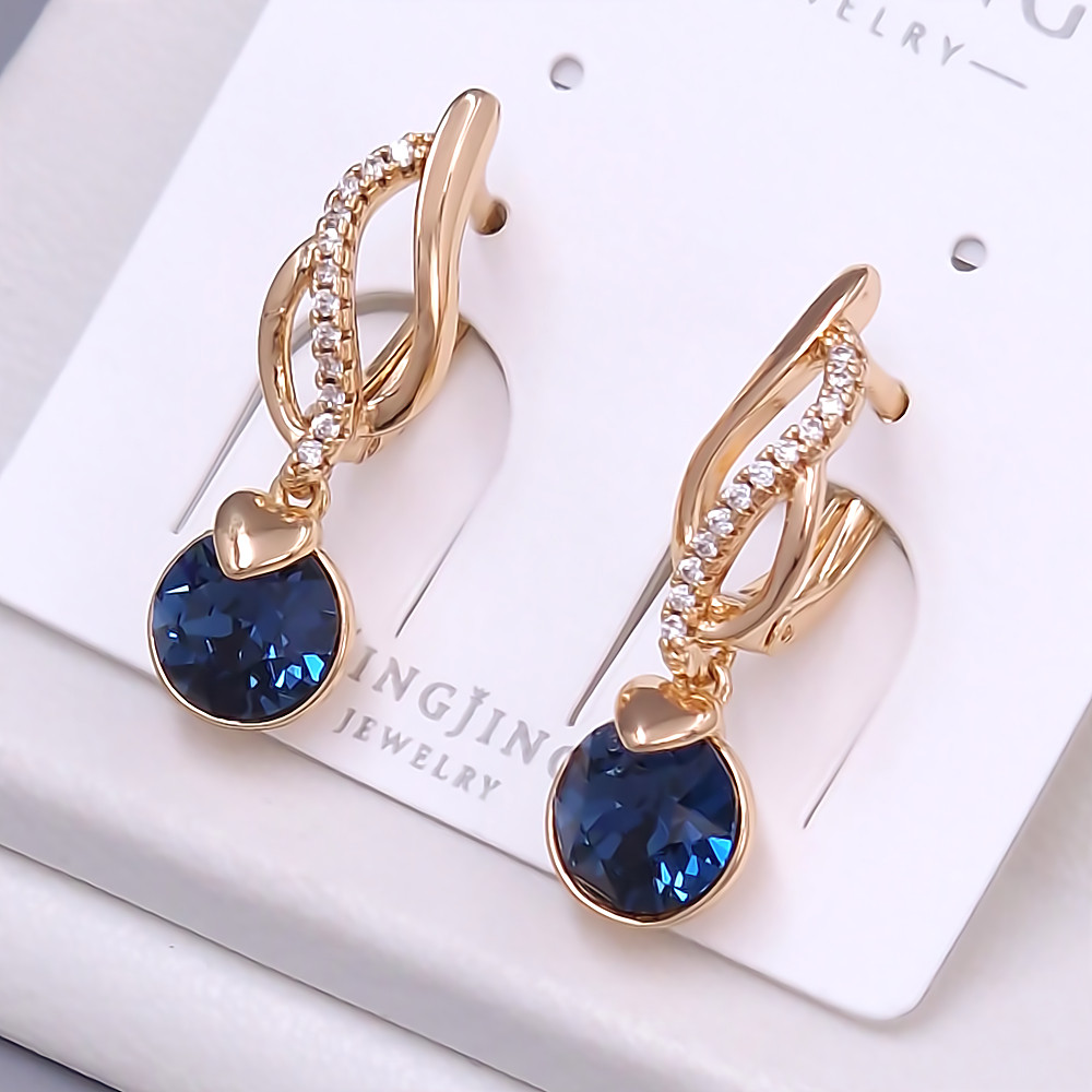 Сережки XР. Позолота 18К. Камені: Swarovski темно-синього кольору та циркон. Довжина: 27 мм. Ширина: 7 мм.
