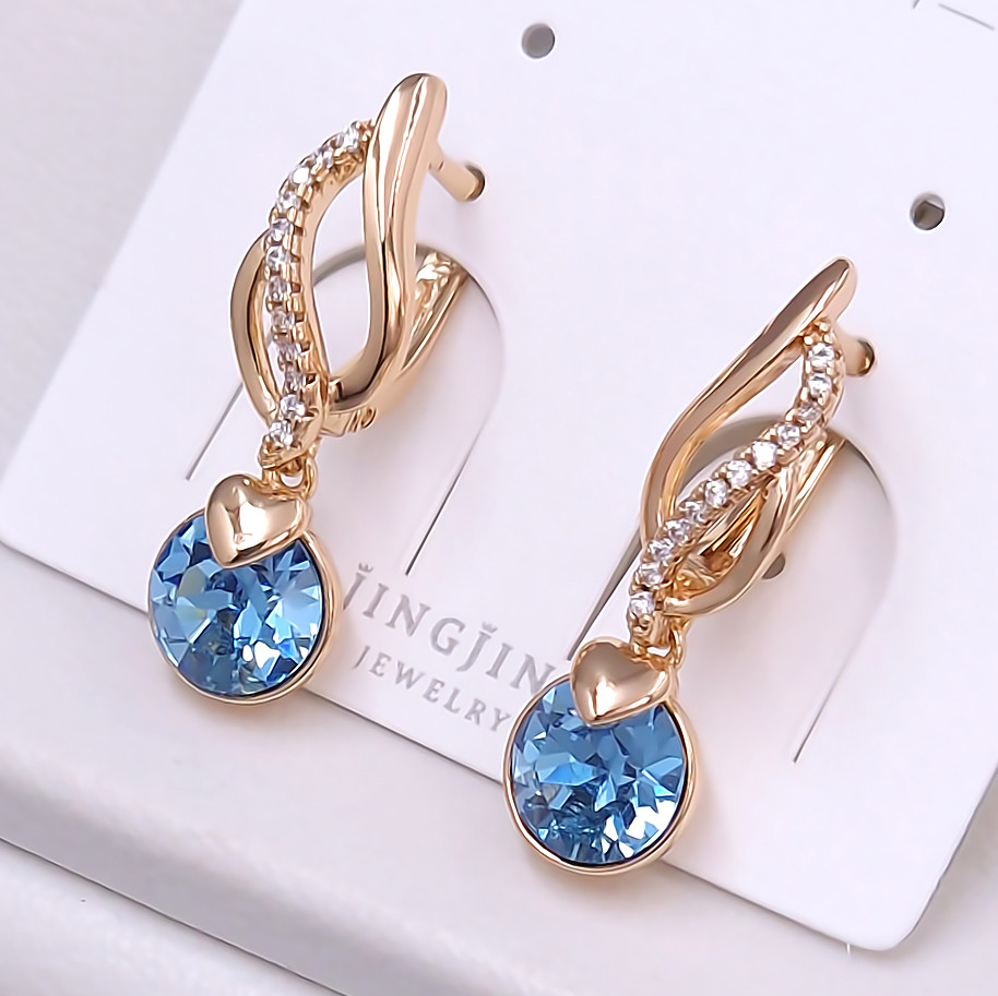 Сережки XР. Позолота 18К. Камені: Swarovski бірюзового кольору та циркон. Довжина: 27 мм. Ширина: 7 мм.