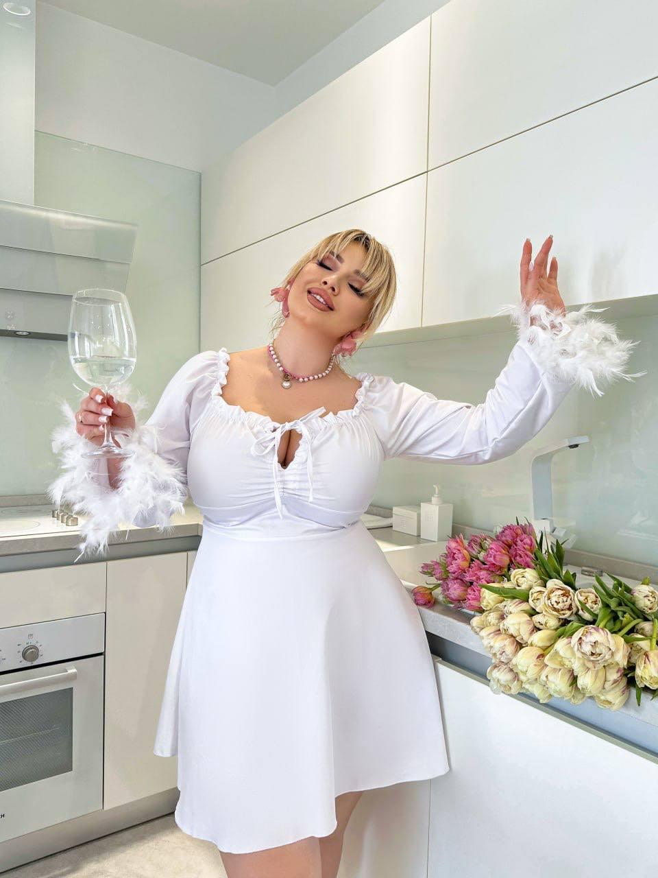 Ошатна біла коротка сукня зі шнурівкою та пір'ям на рукавах