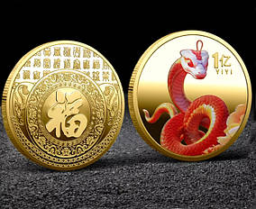 Золота монета з королівською змійкою, символ 2025 року.