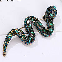 Брошка металева на золотистій основі змія зі смарагдовими кристалами розмір виробу 70х25 мм