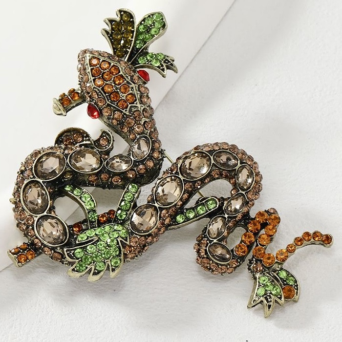 Брошка металева на золотистій основі змія з різнобарвними кристалами розмір виробу 90х80 мм