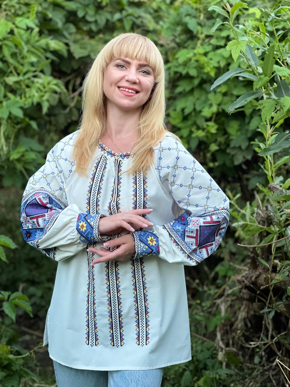 Вишита жіноча блуза-туніка з вишитими візерунками молочна